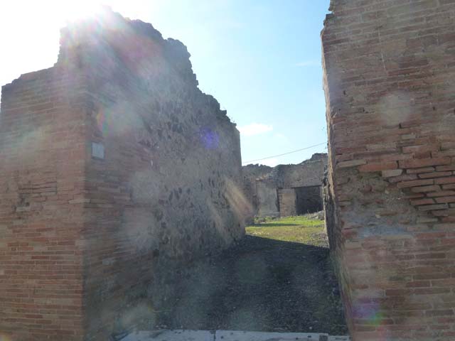 VII.6.30 Pompeii. September 2005. Looking north-west across room with doorway to the garden, on left. On the right of the photo, the destroyed east wall would have contained a niche. According to Boyce, in the east wall of the main room which was entered directly from the fauces was a delicately painted tall, rectangular niche. He thought this was a Lararium. The white background of the surrounding wall was divided by dark stripes into a series of rectangles. These rectangles were in imitation of a veneer of slabs of marble or of a wall built of rectangular blocks of stones.
See Boyce G. K., 1937. Corpus of the Lararia of Pompeii. Rome: MAAR 14. (p.67, no.292)
According to the Notizie degli Scavi, 1910, page 481, on the east wall …… a delicately painted niche, which served as a sacrarium.