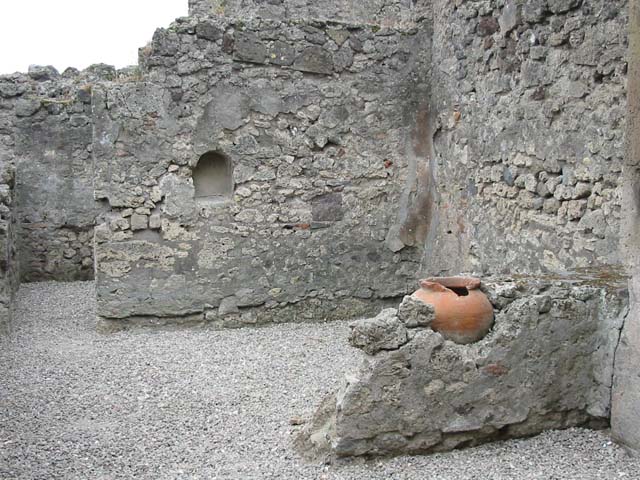 VII.9.49 Pompeii. December 2005. According to L Eschebach there was a two sided counter with two urns of which one remains. Is this the terracotta pot shown here? Above the counter were holes for shelving. See Eschebach, L., 1993. Gebäudeverzeichnis und Stadtplan der antiken Stadt Pompeji. Köln: Böhlau. (p.317).