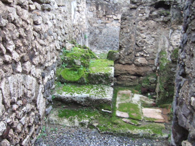 VII.9.64 Pompeii. December 2005. Latrine in north-east corner. According to Hobson when writing “next door to VII.9.63 a new entrance from the street was made. This gave access via a staircase to the upper storey, and to the right of the stairs another new latrine was constructed. This was now back to back with the one in VII.9.63 and emptied into the same cesspit. In addition the staircase led to an upper storey latrine, the down pipe from which was inserted into the wall.
The provision here of three latrines leads one to ask who used each of them?”.
See Hobson, B., 2009. Latrinae et foricae: Toilets in the Roman World. London; Duckworth. (p.68)