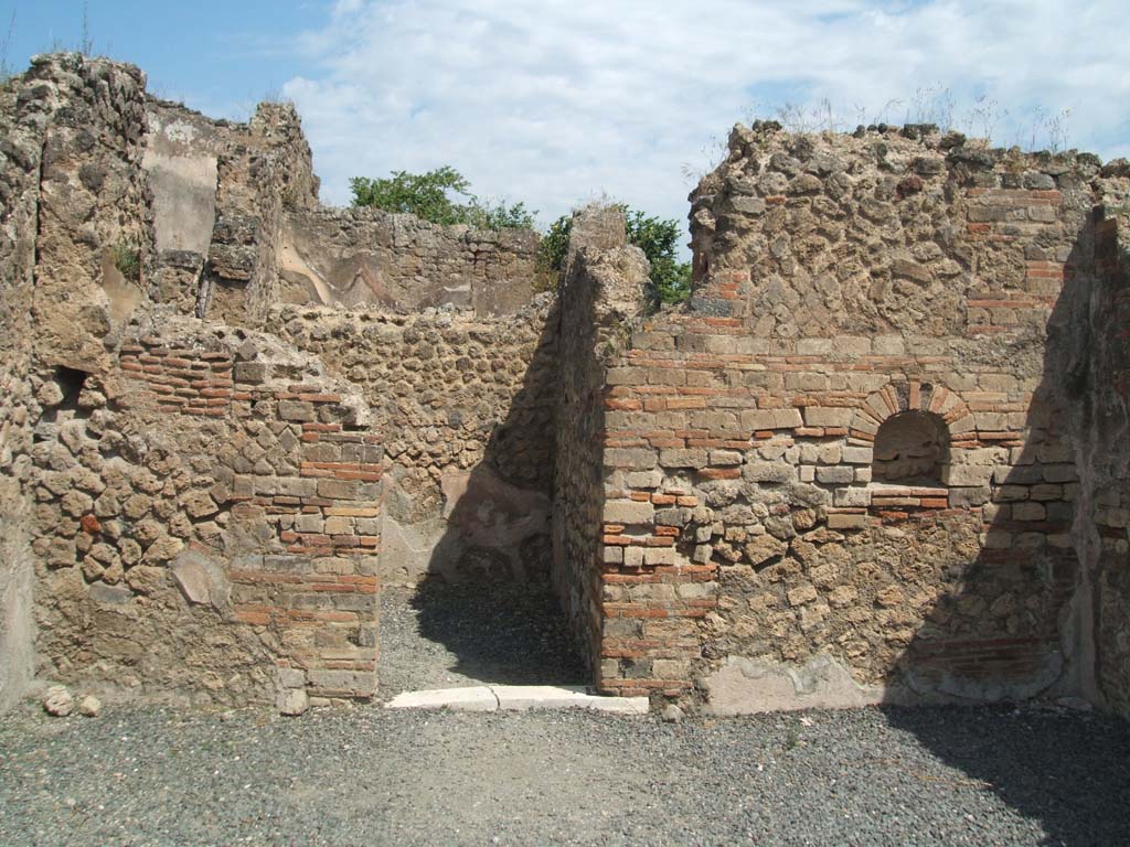 VII.14.8 Pompeii. May 2005. Looking towards north wall of shop, with niche and doorway to rear room.