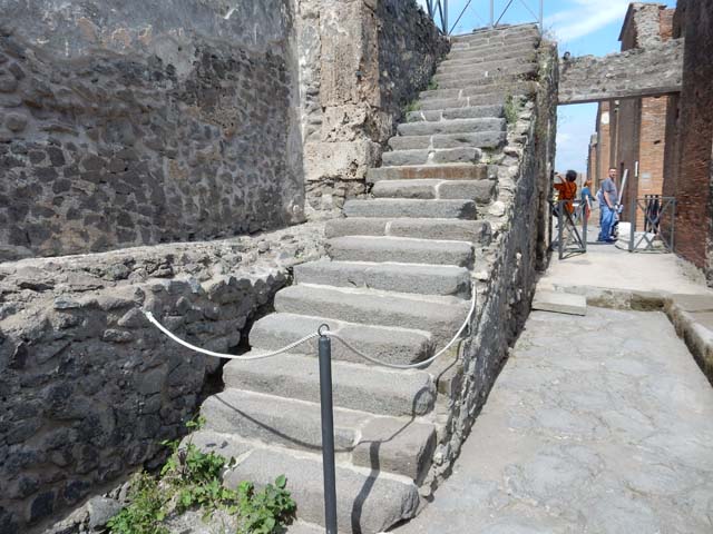 VIII.1.7 Under the steps to upper gallery of the colonnade about the Forum from Via Championnet.  The smaller arch has been filled in and the taller has also been filled in but a new doorway has been made.
