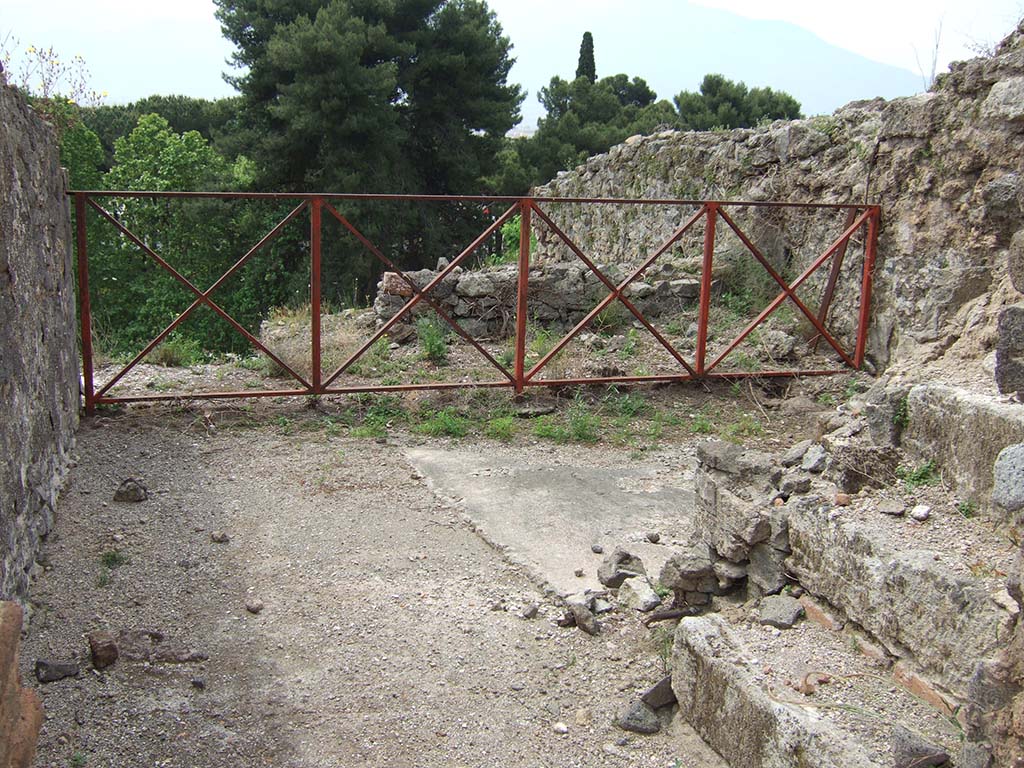 VIII.2.34 Pompeii. May 2006. Looking south through doorway of room ‘o’ with stairs to upper floor, on right.
The floor was formed of a white mosaic with black border, in the centre of which was the emblema showing a lion and panther, below.
