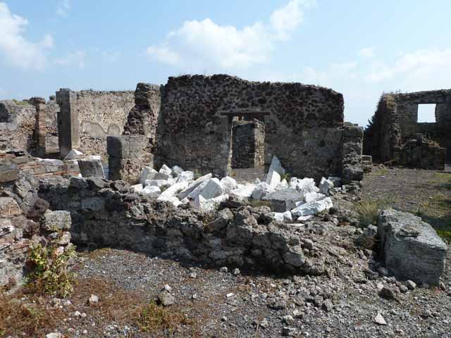 VIII.3.31 Pompeii. May 2010. Looking north-east across portico area towards rooms on the east side of the corridor. The high walls at the rear on the left centre, are the kitchen walls, the other high walls belong to a cubiculum. Taken across the wall of VIII.3.29.
