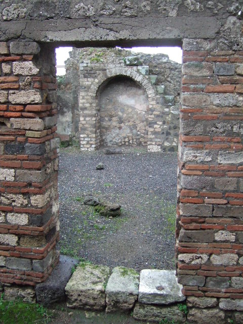 VIII.5.17 Pompeii. December 2005. West wall with doorway, looking into small vicolo.