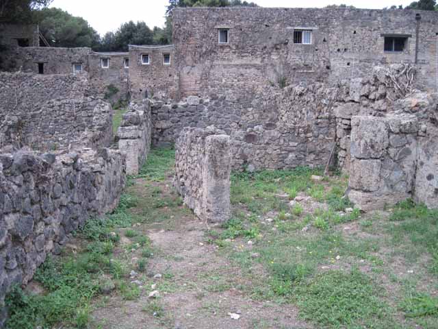 VIII.7.10 Pompeii. September 2010.  Corridor looking east towards road (low wall block in foreground). This would seem to have been taken from the kitchen, but presumably was not blocked in antiquity ?
