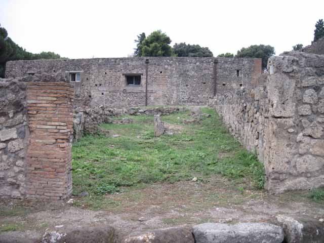 VIII.7.14 Pompeii. September 2010. Looking west across shop, to small rear room on left, and site of corridor with steps to upper floor and kitchen area, on right. Photo courtesy of Drew Baker.
