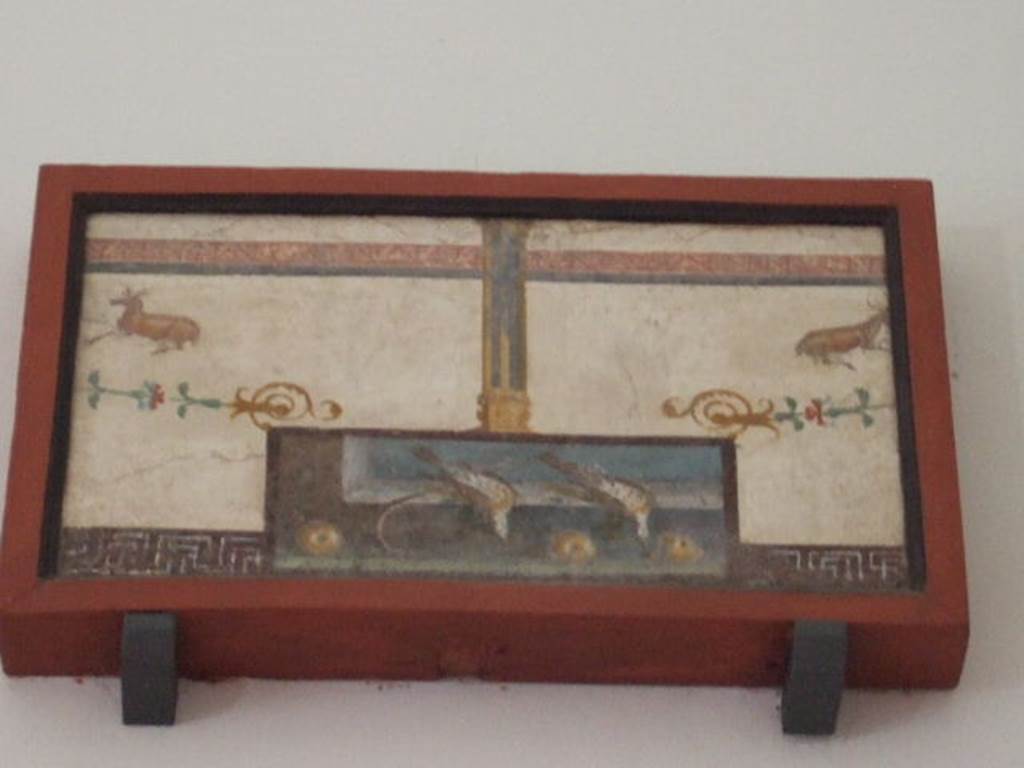VIII.7.28 Pompeii. Found on left feature of east wall. Still life surmounted by Delphic tripod. Now in Naples Archaeological Museum. Inventory number 8695.


