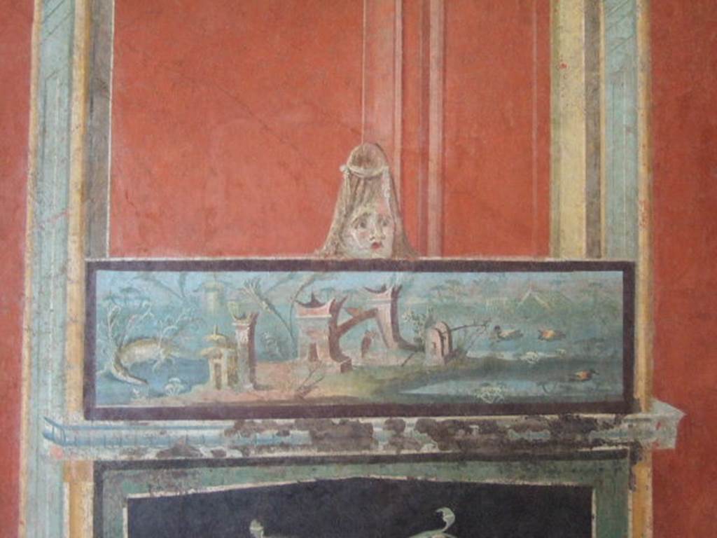 VIII.7.28 Pompeii. Ultimate panel on the right of the east wall. Detail of architectural scene with Nilotic painting surmounted by a mask. Now in Naples Archaeological Museum. Inventory number 8539.