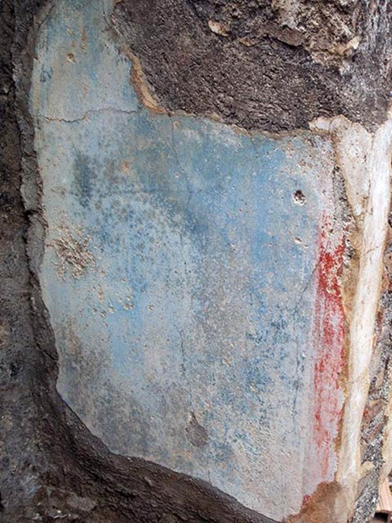 IX.2.27 Pompeii. May 2005. Remains of painted blue and red plaster on inside of north wall of shrine.