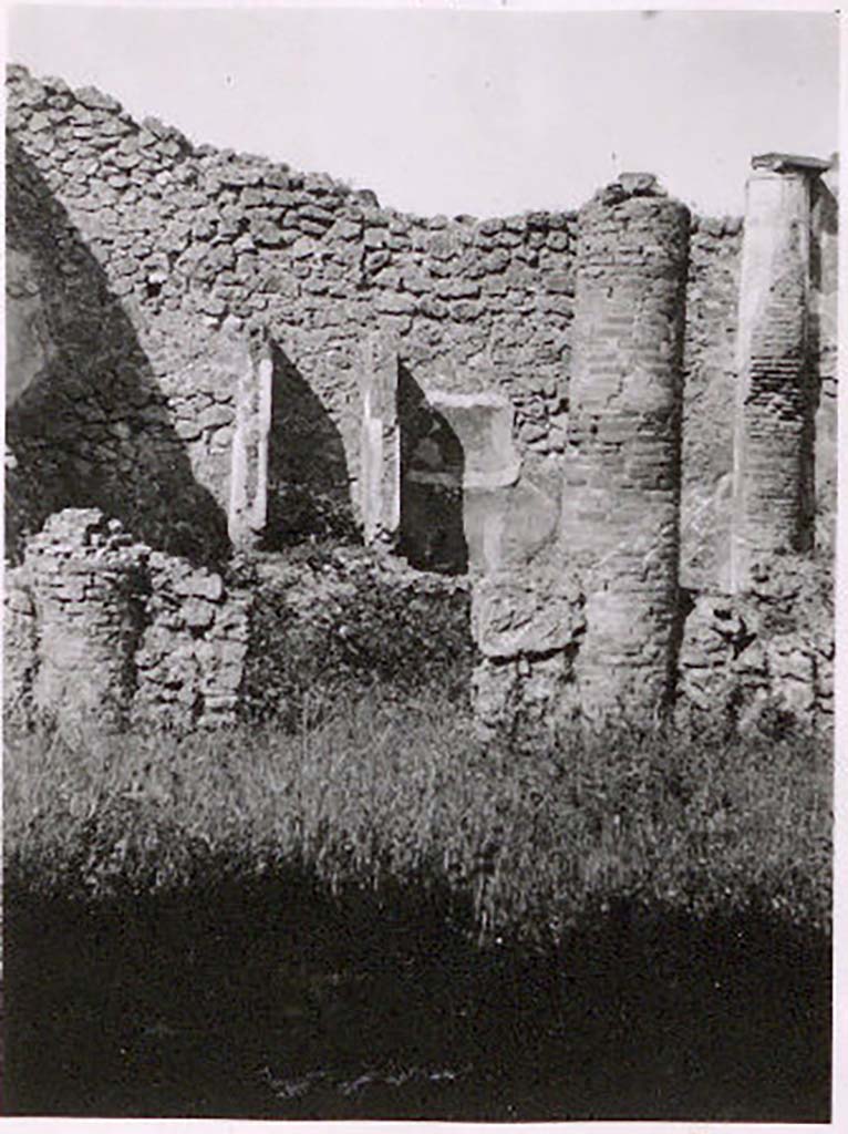 IX.2.27 Pompeii. Pre-1943. Photo by Tatiana Warscher.
According to Warscher – this house may have served as a workshop.
Against the west wall of the peristyle-like room entered directly from the street, stands a shrine; 
above a low podium (1.10 x 0.70, height 0.40) two enclosing walls (height as far as preserved 1.30) built against the wall of the room form a rectangular niche (w.0.60, d. 0.50). The floor is not preserved. The inside walls are painted with blue with red borders.
On the ground in front of the shrine stands a square masonry altar.
Giorn. Scavi, N.S, ii, 1870, p.10.
Bull. Inst., 1871, p.177.
See Warscher, T. Codex Topographicus Pompeianus, IX.2. (1943), Swedish Institute, Rome. (no.136.), p. 251.
