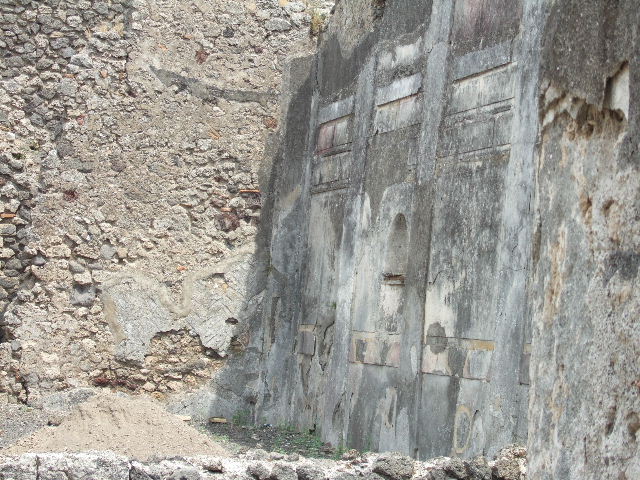 IX.3.2 Pompeii. March 2009. Garden area. Niche in south wall.  The niche was originally decorated with yellow, red and green flowers.
See Giacobello, F., 2008. Larari Pompeiani: Iconografia e culto dei Lari 
in ambito domestico. Milano: LED Edizioni. (p.284).
According to Boyce, the inside walls were decorated on a white background with red and yellow spots and outlined with red stripes.
The two Lares were painted on the wall above the niche and below it the serpents, confronted at an altar.Bronze statues were found in the niche on12th July 1847: a female figure, a male figure, Hercules, Jupiter, and Isis-Fortuna.
See Boyce G. K., 1937. Corpus of the Lararia of Pompeii. Rome: MAAR 14. (p. 82, Pl. 4, 2.) 
Helbig also gave a description of the statuettes found in the niche:
See Helbig, W., 1868. Wandgemälde der vom Vesuv verschütteten Städte Campaniens. Leipzig: Breitkopf und Härtel. (69b)


