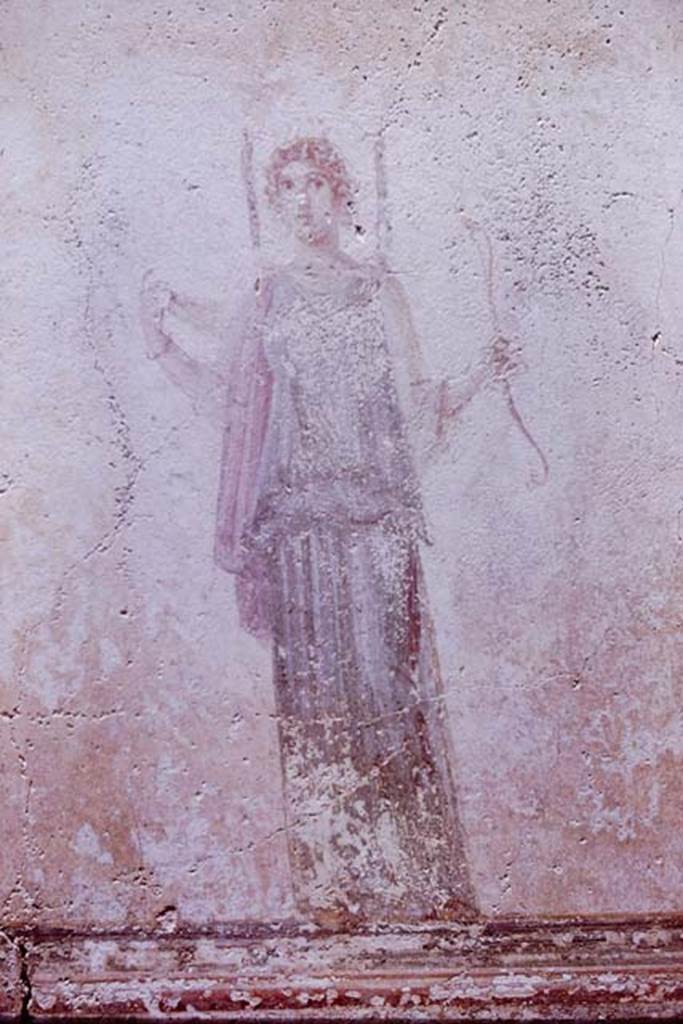 IX.8.3 Pompeii. 1961. Painting of Diana (Artemis) from north wall. Photo by Stanley A. Jashemski.
Source: The Wilhelmina and Stanley A. Jashemski archive in the University of Maryland Library, Special Collections (See collection page) and made available under the Creative Commons Attribution-Non Commercial License v.4. See Licence and use details. J61f0410
According to Bragantini, de Vos, Badoni, Diana is holding a serpent in her hand. 
This photograph seems to indicate that she was, in fact, holding a bow.
See Bragantini, de Vos, Badoni, 1986. Pitture e Pavimenti di Pompei, Parte 3. Rome: ICCD. (p.513)

