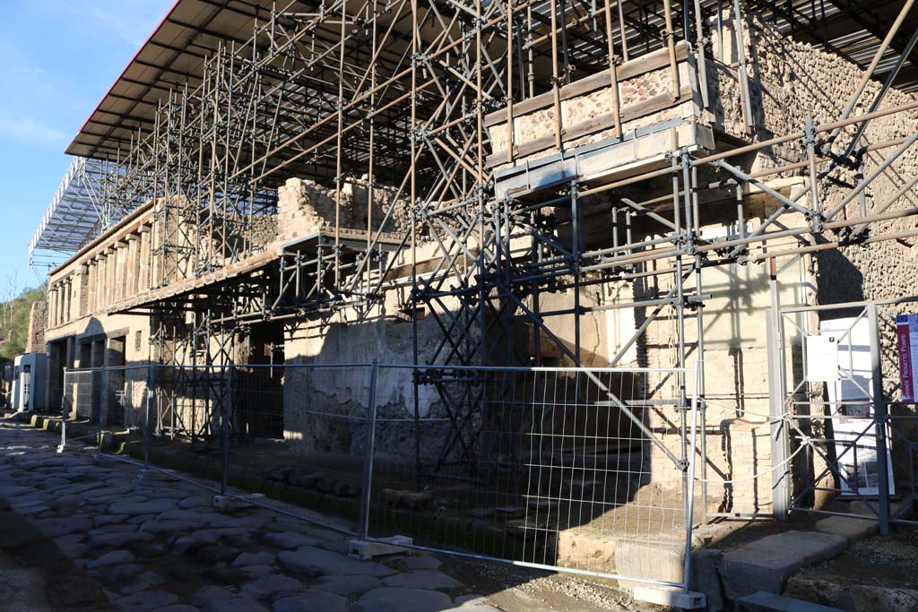 IX.12.7 Pompeii. February 2010. Via dell’Abbondanza looking west, with balcony remains above the PompeiViva frontage. Photo courtesy of Rick Bauer.