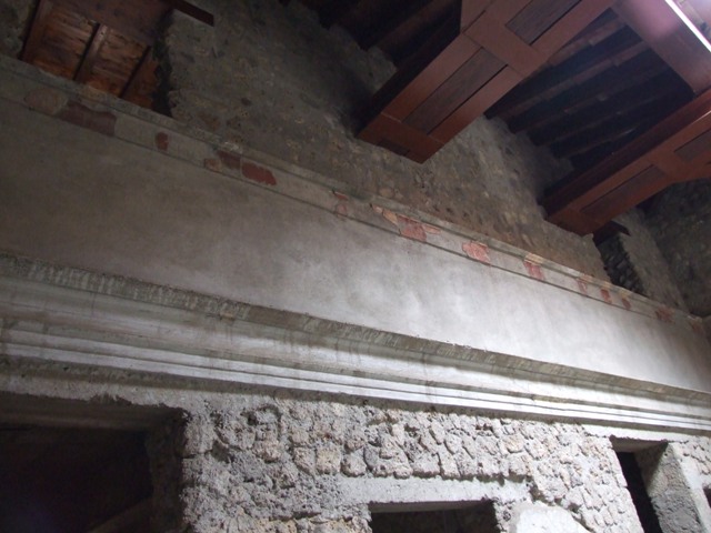 IX.13.1-3 Pompeii. September 2004. Room 21. 
Lararium by west wall of services atrium, near door to kitchen.
Two Lares, much taller than all the other figures, stand on either side. 
A Genius and a small Tibicen and a round altar are between them. 
By the round altar dressed in blue and red is Juno. 
A large snake winds round the altar.  See Fröhlich, T., 1991. Lararien und Fassadenbilder in den Vesuvstädten. Mainz: von Zabern. (L109).
