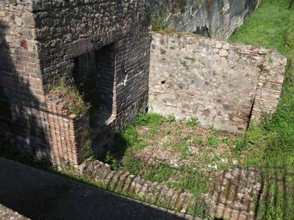 HGW24 Pompeii. May 2010. Room in south-west corner of garden area.
According to Garcia y Garcia, a bomb was dropped here during the night of 18th September 1943.
This bomb fell on the south-west corner of the peristyle causing the destruction of part of the wall south of the turret and the collapse of the rear slope.
It was restored in 1946.
See Garcia y Garcia, L., 2006. Danni di guerra a Pompei. Rome: L’Erma di Bretschneider. (p.160-1)
According to Boyce, a small room opened off the south-west corner of the large portico surrounding the garden.
This room had a semi-circular niche in the east wall. The room was called a lararium in the reports.
See Boyce G. K., 1937. Corpus of the Lararia of Pompeii. Rome: MAAR 14. (p.97, no.478). 
(Fontaine, room 5,2).
