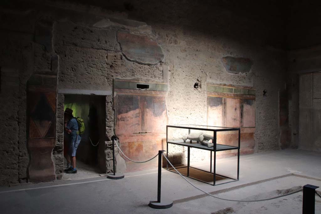 Villa of Mysteries, Pompeii. April 2014. Room 64, looking towards north wall of atrium and north-east corner. 
The doorway to corridor F2 can be seen on the left, on the right is the doorway to the peristyle. 
Photo courtesy of Klaus Heese.
