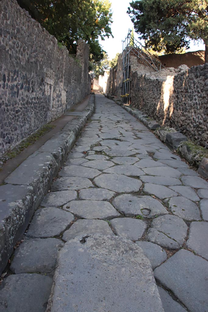 Vicolo delle Pareti Rosse, Pompeii. October 2022. 
Looking west between VIII.6. Pompeii, on left, and VIII.5, on right. Photo courtesy of Klaus Heese. 
