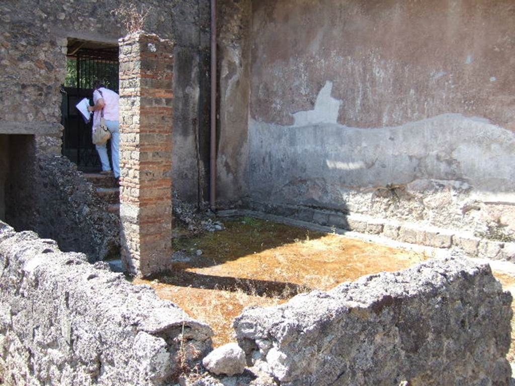 I.6.2 Pompeii. May 2006. Looking south-west across the small peristyle garden.
The garden was enclosed with a low wall on the north and east sides.
The large brick pillar used to support the roof of the portico.
Behind the pillar are the stairs leading up to the summer loggia with triclinium.
See Jashemski, W. F., 1993. The Gardens of Pompeii, Volume II: Appendices. New York: Caratzas. (p. 34).