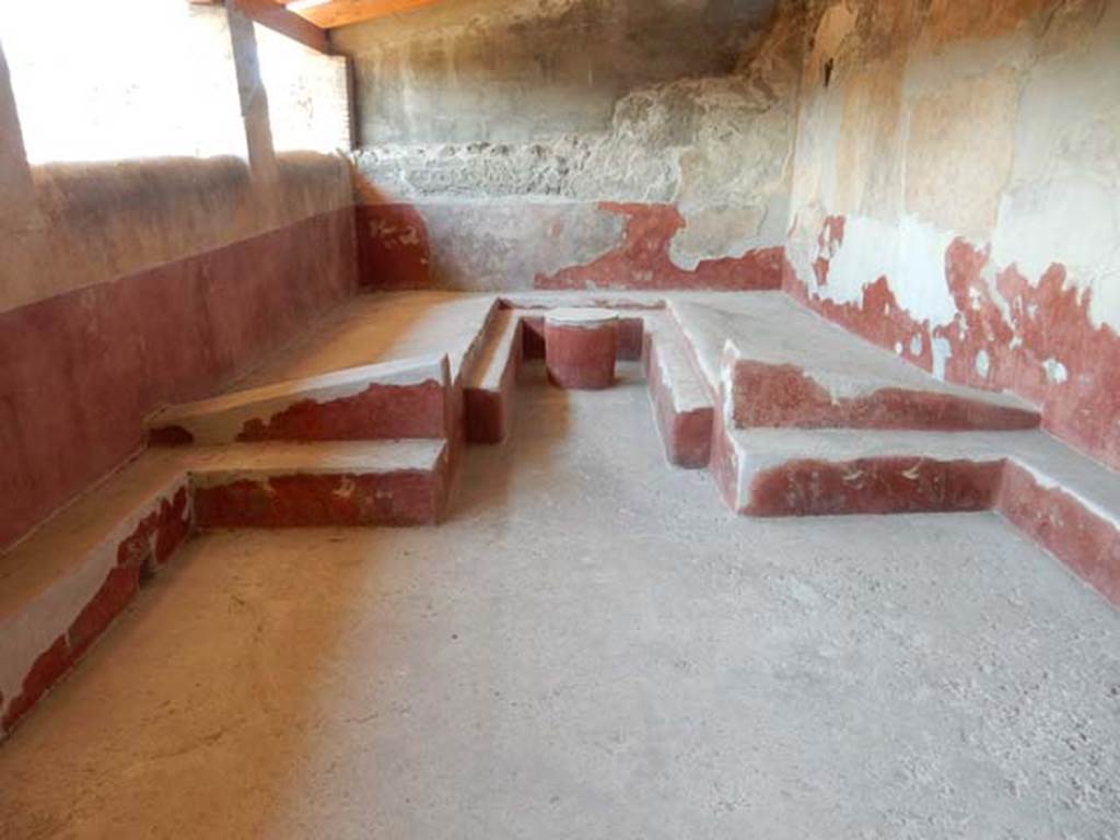 I.6.2 Pompeii. May 2016. Triclinium with table, against the west wall of the loggia.
The circular table, the couches and the benches, were all painted with motifs of plants and birds on a red background.
Photo courtesy of Buzz Ferebee.