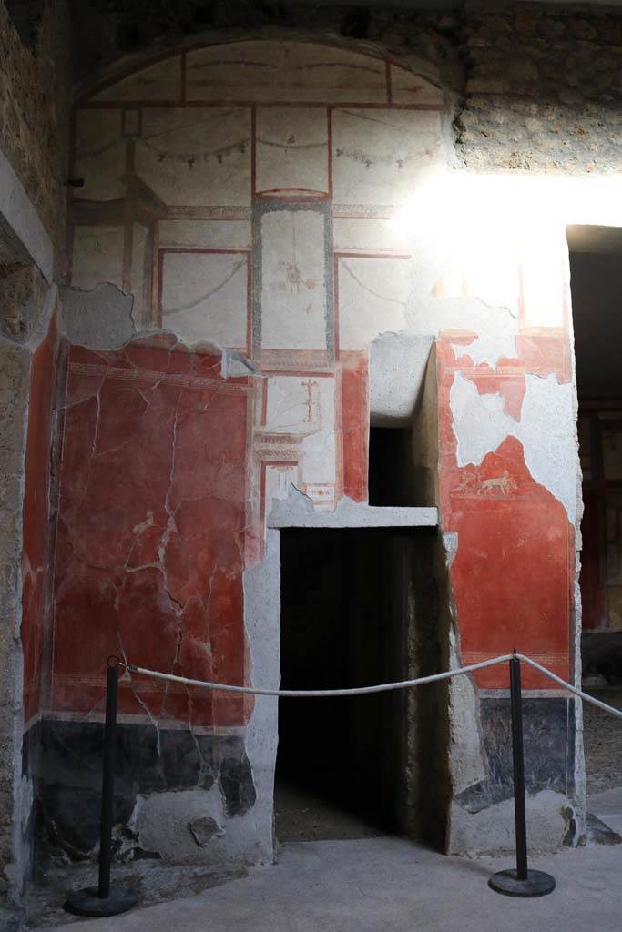 I.6.7 Pompeii. December 2018.
Doorway to room in north-east corner of atrium, with a splayed window above.
On either side of the doorway are small paintings.
On the north side – an antelope, on the south side – a chariot with the attributes of Dionysus being pulled by panthers.
Photo courtesy of Aude Durand.