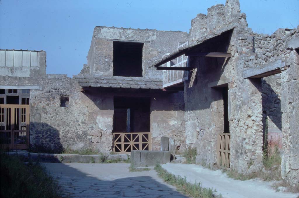 Vicolo del Menandro, Pompeii. August 1976.
Looking east to end of the Vicolo with fountain at its junction with Vicolo di Paquius Proculus.
On the left and centre are I.7.19 and I.7.18. On the right is I.10.1 and I.10.2.
Photo courtesy of Rick Bauer, from Dr George Fay’s slides collection.