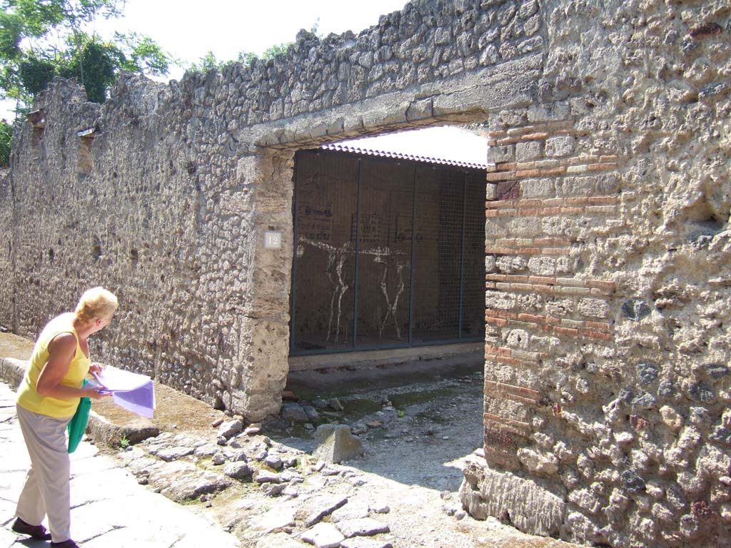 I.8.12 Pompeii. September 2005. Entrance doorway, with “break” in pavement permitting entry of carts.
According to Wallace-Hadrill, this entrance led to a stable-yard, with a rear room and stairs to upper level.
See Wallace-Hadrill, A. (1994): Houses and Society in Pompeii and Herculaneum. UK, Princeton Univ. Press, (p.192)