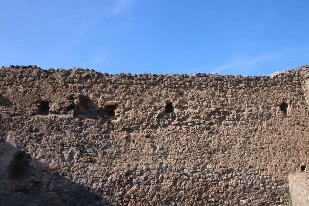 I.8.12 Pompeii. October 2022.
Looking towards upper north wall with holes for support beams for an upper floor. Photo courtesy of Klaus Heese.