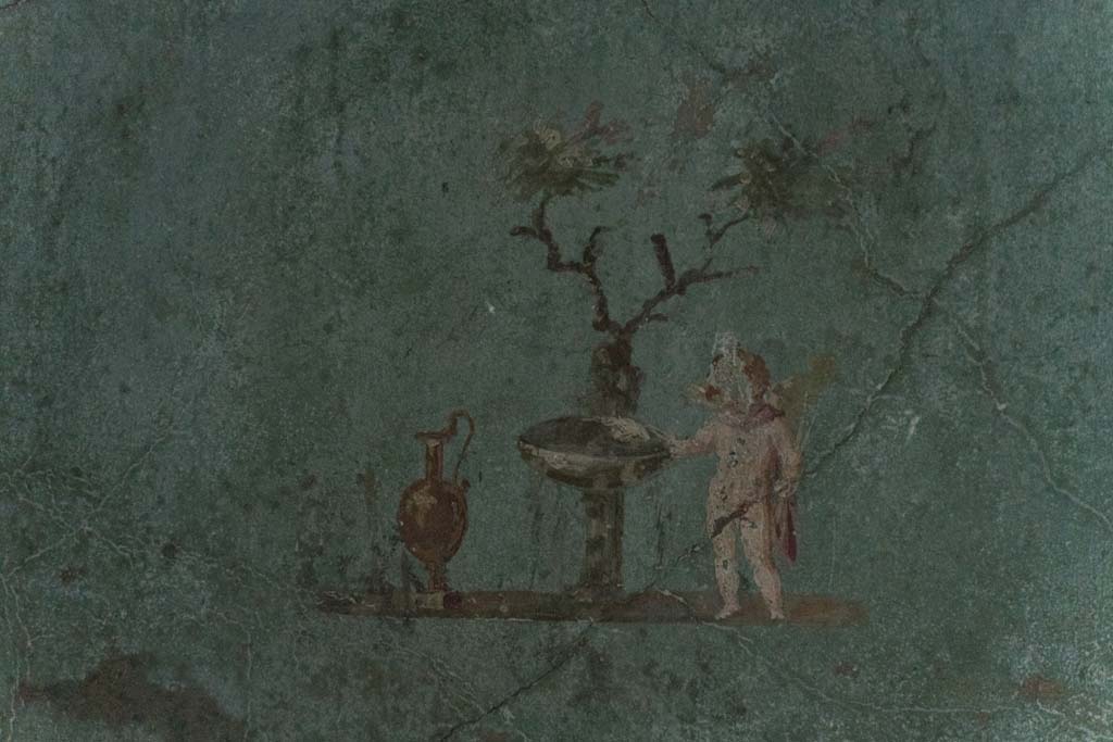 I.10.4 Pompeii. April 2022.
Room 48, painted cupid with jug, fountain basin and tree in rectangular recess. Photo courtesy of Johannes Eber.