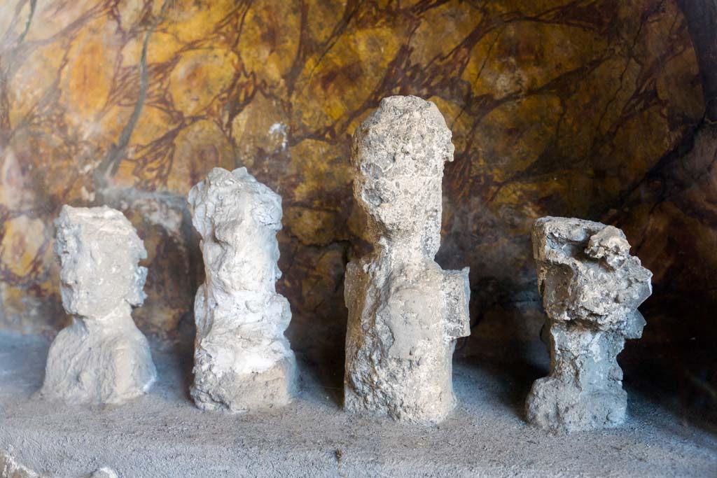 I.10.4 Pompeii. April 2022.
Alcove 25, lararium or domestic shrine, plaster casts of the original wooden ancestor images. Photo courtesy of Johannes Eber.
According to Cicirelli, these are imagines maiorum, ancestor images, and were accompanied a statuette of a sitting youth, identified as a lar.
See Stefani, G. (Ed), 2003. Menander: La casa del Menandro di Pompei. Milano: Mondadori Electa. (p. 187).
