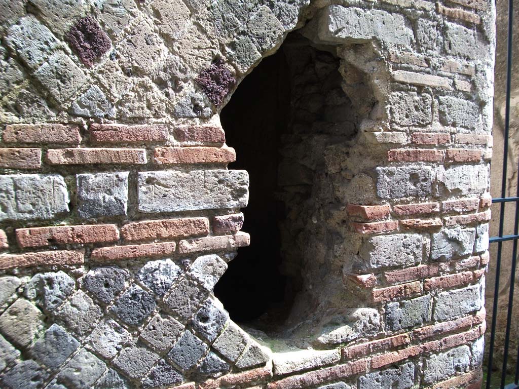 I.10.4 Pompeii. May 2010. P1, east wall, with ancient hole made by fugitives trying to escape in 79AD.
According to Allison, the 10 skeletons discovered in this corridor might have been part of the same party as the 3 skeletons found with a pick and a hoe in room 19 on the other side of the hole.
They appear to have been people who probably suffocated whilst trying to escape during the final eruption.
They included at least 3 children under the age of 5.
The age of the children and the victims being on both sides of the wall and with tools would suggest they were probably victims rather than post-eruption intruders.
See Allison, P.M., 2004. Pompeian Households: An analysis of the material culture. Los Angeles: UCLA Cotsen Institute. (p. 24; p. 180).