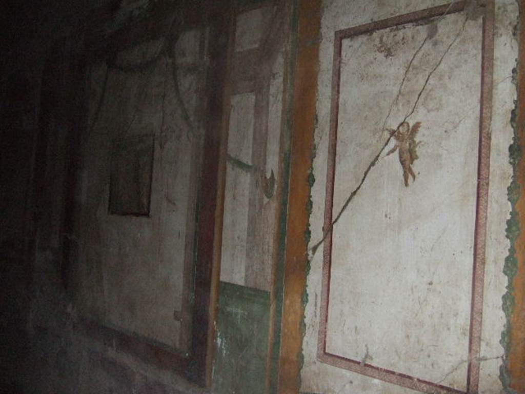 II.3.3 Pompeii. December 2005. Room 4, south wall of cubiculum.
A flying cherub is on the near panel. The remains of a wall painting of Hermes and Dionysus is in the central wall panel.