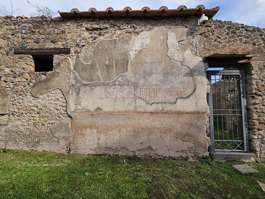 II.4.10 Pompeii. November 2024.
Exterior wall with painted inscriptions on north side of entrance doorway. Photo courtesy of Annette Haug.