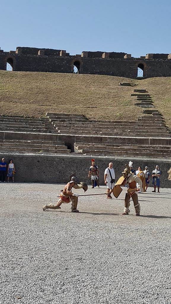 II.6 Pompeii. September 2024.
Looking west towards Gladiators in combat rehearsing.
Photo courtesy of Giuseppe Ciaramella.