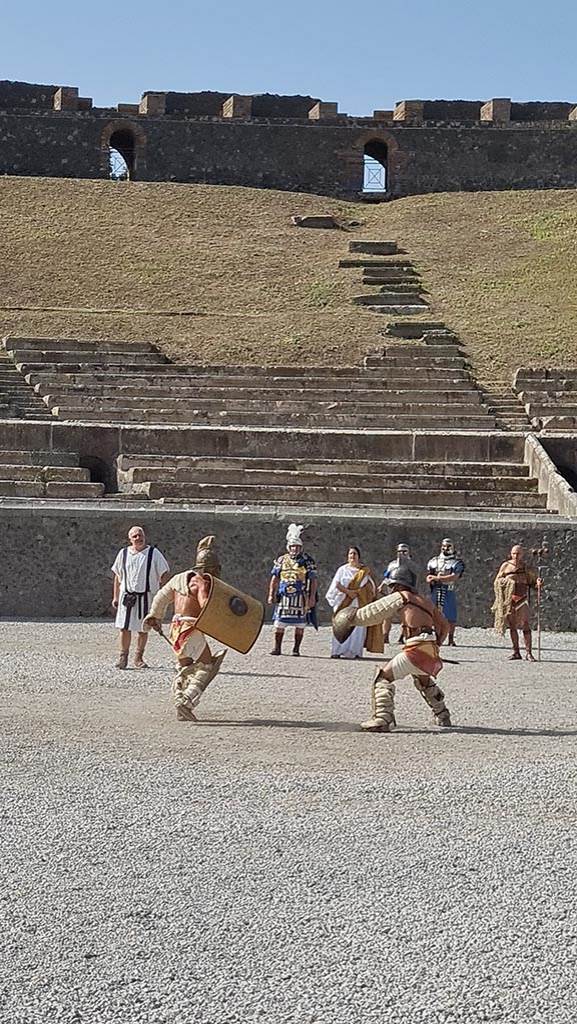 II.6 Pompeii. September 2024.
Gladiators in combat rehearsing in amphitheatre.
Photo courtesy of Giuseppe Ciaramella.