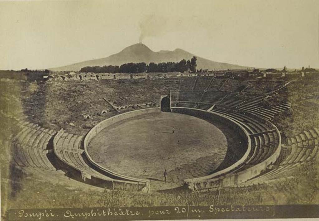 II.6 Pompeii. Old undated photograph by Mauri, no.024. Looking north across amphitheatre to a smoking Vesuvius. Photo courtesy of Rick Bauer.