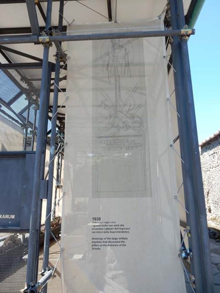 III.3.7, Pompeii. May 2018. East entrance pillar display notice.
Drawings, from 1930, of the large military trophies that decorated the pillars at the entrance of the Schola.
Photo courtesy of Buzz Ferebee.