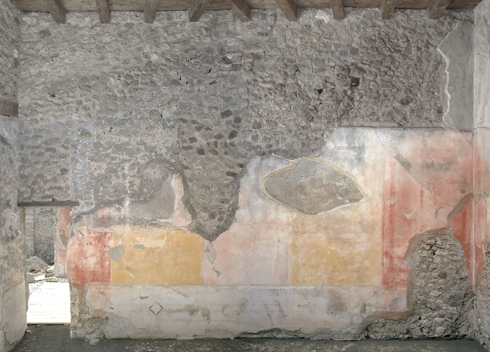 V.1.18 Pompeii. 2012.
Room “p”, oecus, looking towards west wall with doorway into exedra “o”. Photo by Hans Thorwid.
“West wall in 2012.
Restored parts of the wall photographed and merge with the lower part and floor line of earlier photos from 2005-07.”
Photo and words courtesy of The Swedish Pompeii Project.