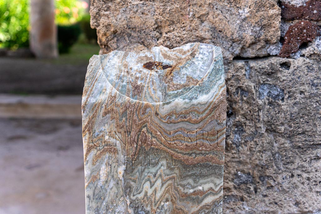 V.1.26 Pompeii. October 2023.
Room “b”, detail of marble pillar, with wording - GENIO L NOSTRI FELIX L. Photo courtesy of Johannes Eber.