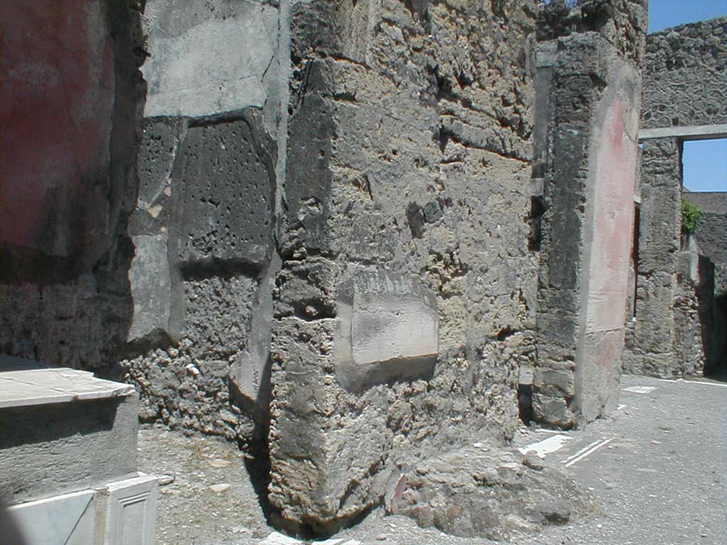 V.1.26 Pompeii. May 2005. Room “b”, atrium. Looking north-east to rooms, “c” and “d”.  
The remains of the base for the money chest are between the two cubicula doors.
According to Pernice –
In the atrium on the left between the first two rooms was a base made of lava and tuff pieces.
See Pernice, E., 1932. Hellenistische Tische, Zisternenmündungen, Beckenuntersätze, Altäre u. Truhen. Berlin, p. 75, no. 22.
Thanks to Espen B. Andersson for assisting us in our interest in money-chests.

