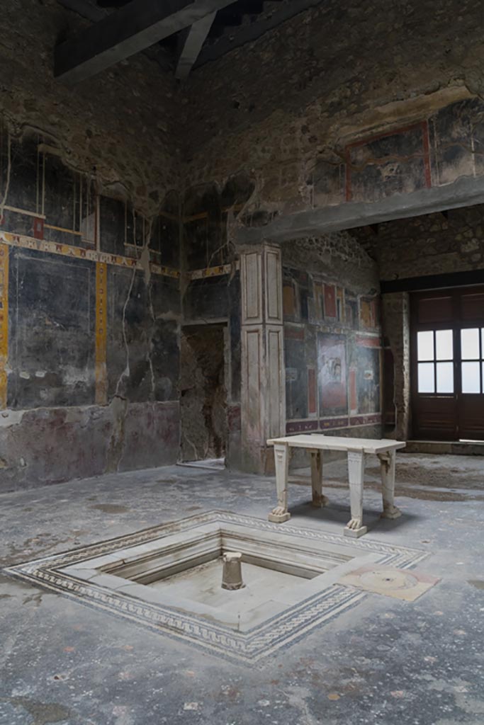 V.4.a Pompeii. March 2023.
Atrium ‘b’, north-east corner with doorway to corridor ‘k’, and tablinum ‘h’.
Photo courtesy of Johannes Eber.