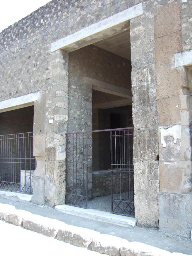 VI.2.4 Pompeii. May 2006. Entrance.
According to Breton, on either side of the entrance doorway were two pilasters surmounted with sculptured grey lava capitals.
He could see one of them, which represented a Satyr teaching a young Faun to play the pipes. Today, all had disappeared.
See Breton, Ernest. 1870. Pompeia, Guide de visite a Pompei, 3rd ed. Paris, Guerin. 

According to Della Corte –
this house was originally attributed to Caius Sallustius, who was nominated for election in the inscription on the exterior house wall, no longer visible.
Originally the beautiful and noble house would have been in the hands of an old established Pompeian family, who must remain unknown.
By 79AD, it was transformed into one of the biggest hospitiums or hotels in Pompeii.  
The owner was then more likely to be A. Cossius Libanus, a man possibly of oriental descent, whose bronze seal was found in the house in September 1806.
 It read - A. Coss(ius) liban(us)  (S.33 or CIL X 8058,27)
See Della Corte, M., 1965. Case ed Abitanti di Pompei. Napoli: Fausto Fiorentino. (p.38)

According to Epigraphik-Datenbank Clauss/Slaby (See www.manfredclauss.de) the electoral recommendation read - 

C(aium) Sallustium       [CIL IV 104]
