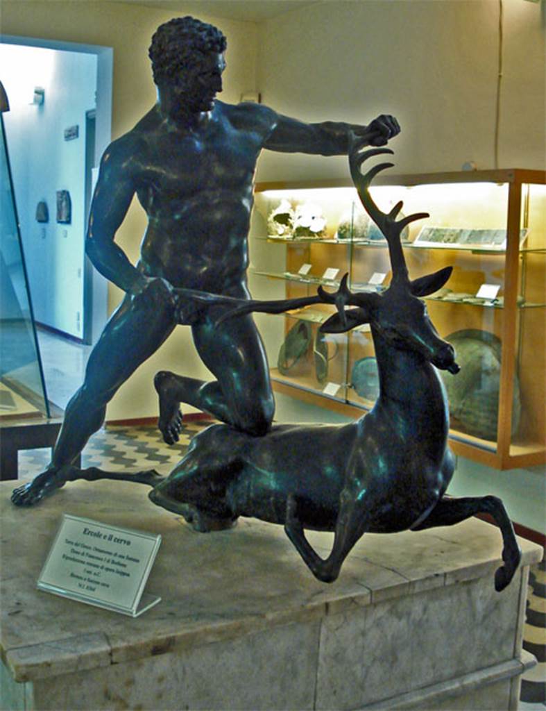 VI.2.4 Pompeii. Hercules conquering the Stag of Cerinea, found on east side of impluvium. According to Anne Laidlaw, some of the major finds made during the first official excavation, in February of 1805 in front of Queen Maria Carolina, the Bourbon queen, were taken by her to Palermo when the French took over in March of 1806 under Napoleon, and now are in the Palermo Regional Archaeological Museum. The most striking was a large bronze fountain group of Hercules and the Stag, which was found at the back of the impluvium on a pedestal. All that you can see now in the impluvium margin are some sockets which either were for the waterworks or for the pedestal. 
Recent measurements of the pedestal and basin carried out for her in Palermo, were checked against the sockets in the impluvium margin in Sallust, and came out perfectly.
This would confirm the statue came from VI.2.4 and not Torre del Greco as shown on the museum card. Now in Palermo Regional Archaeological Museum. Inventory number 8364 or 8634. According to Breton, on a base of marble in the centre of the impluvium, was found a bronze group representing Hercules conquering the stag, from the mouth of which flowed a jet of water. This group is now in the Museum of Palermo, and a copy in plaster in the Museum at Naples. See Breton, Ernest. 1870. Pompeia, Guide de visite a Pompei, 3rd ed. Paris, Guerin.  See Pagano, M. and Prisciandaro, R., 2006. Studio sulle provenienze degli oggetti rinvenuti negli scavi borbonici del regno di Napoli.  Naples : Nicola Longobardi. (p.95, dated 5 Feb 1805). See Pagano, M., 1997. I Diari di Scavo di Pompeii, Ercolano e Stabiae di Francesco e Pietro la Vega (1764-1810.) Rome: L'Erma di Bretschneider. (p. 168). Photograph courtesy of Giovanni dall’Orto: Wikimedia creative commons.
