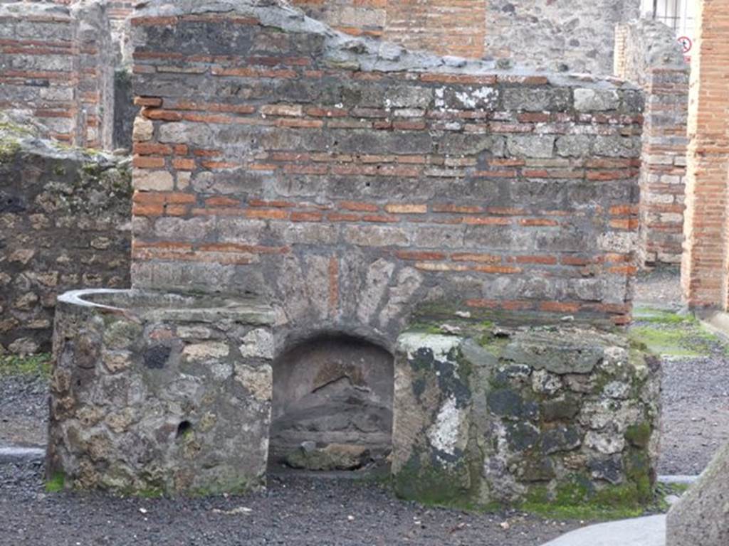 VI.3.3 House of the Baker or Casa del Forno. Site of the household altar.
In POMPEII, it’s life and art, by AUGUST MAU, pages 388-392 – he states “at “c” there is a cistern curb (kerb?), with a large earthen vessel for holding water on either side, while the wall above was ornamented with a painting representing Vesta, the patron goddess of bakers, between the 2 Lares”.
In WANDEGEMALDE der vom Verschutteten stadte, by WOLFGANG HELBIG he states that there is “In the pistrinum: Indistinct Sacred painting, 85“