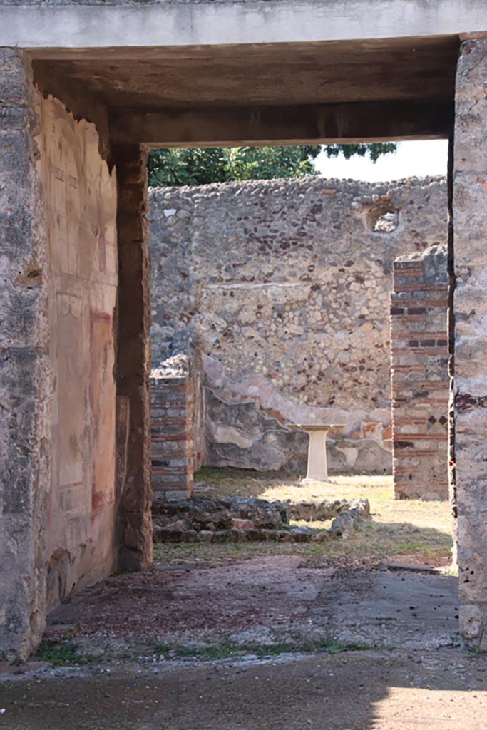 VI.7.23 Pompeii. October 2022.
Looking west through tablinum towards remains of pyramidal fountain in courtyard, and triclinium with table.
Photo courtesy of Klaus Heese.