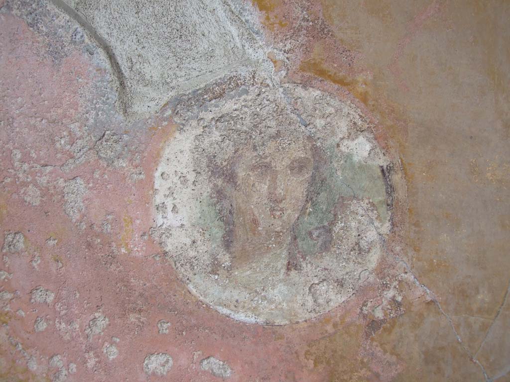 VI.7.23 Pompeii. December 2006. Detail of face in medallion on east end of south wall of tablinum.