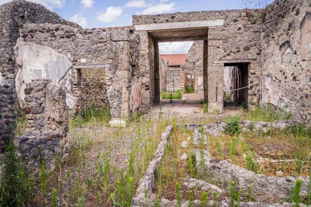VI.7.23 Pompeii. July 2021.
Looking east across remains of pyramidal fountain in courtyard, towards doorway to cubiculum with window (left), tablinum, and corridor.
Photo courtesy of Johannes Eber.