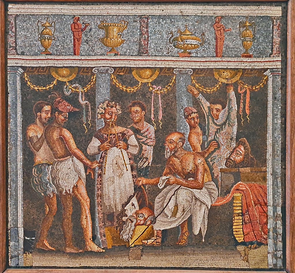 VI.8.3/5 Pompeii. September 2024. Room 6, tablinum with mosaic floor, linking VI.8.3 to VI.8.5.
In the centre of the mosaic floor would have been the mosaic emblema.
Now in Naples Archaeological Museum. Inventory number 9986. Photo courtesy of Giuseppe Ciaramella.
According to Mau this is an emblema of an actor making preparations for the stage and was found in the floor of the tablinum.