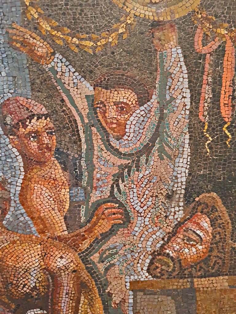 VI.8.3/5 Pompeii. September 2024.
Detail from mosaic of a youth helping another actor put on his costume. Photo courtesy of Giuseppe Ciaramella.
