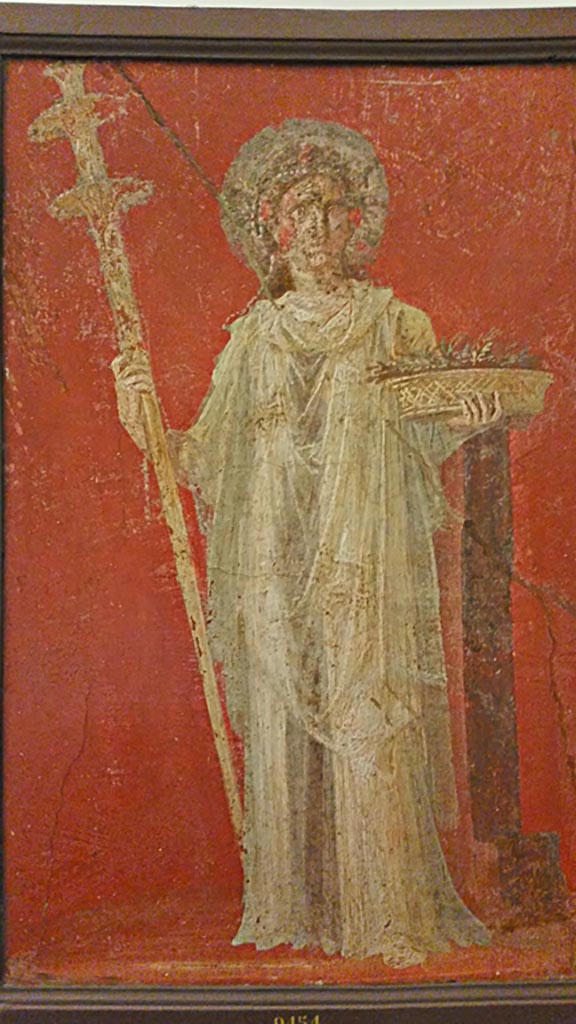 VI.9.6 Pompeii.
Wall painting of Ceres holding a long torch and a basket full of ears of grain.
One of two paintings that flanked the door in the deep bay of the atrium that formed a vestibule for the peristyle.
Now in Naples Archaeological Museum. Inventory number 9454.
Photo courtesy of Giuseppe Ciaramella, November 2018.