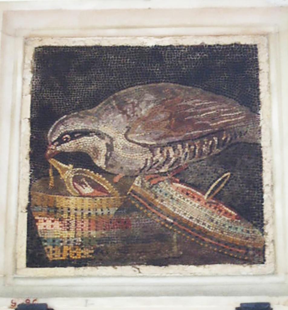 VI.11.10 Pompeii. Found in room 45, small room on right side of room 43, on 10th September 1835.
Mosaic of partridge stealing a mirror.
Now in Naples Archaeological Museum, inventory number 9980.
See Pagano, M. and Prisciandaro, R., 2006. Studio sulle provenienze degli oggetti rinvenuti negli scavi borbonici del regno di Napoli. Naples: Nicola Longobardi. (p.151) PAH II, 316.
According to Fiorelli in PAH, II, (p.316) –
10th September 1835. And in the floor of the small room on the right, near to the right corner at the head of the magnificent tablinum, we have discovered a square mosaic sized 10.37 inches squared (0.26m squared) or in italian “di pal. 1 in quadro”, embedded in a piece of marble, showing a partridge in the act of removing a jewel from a beautiful chest whose lid has been overturned.”